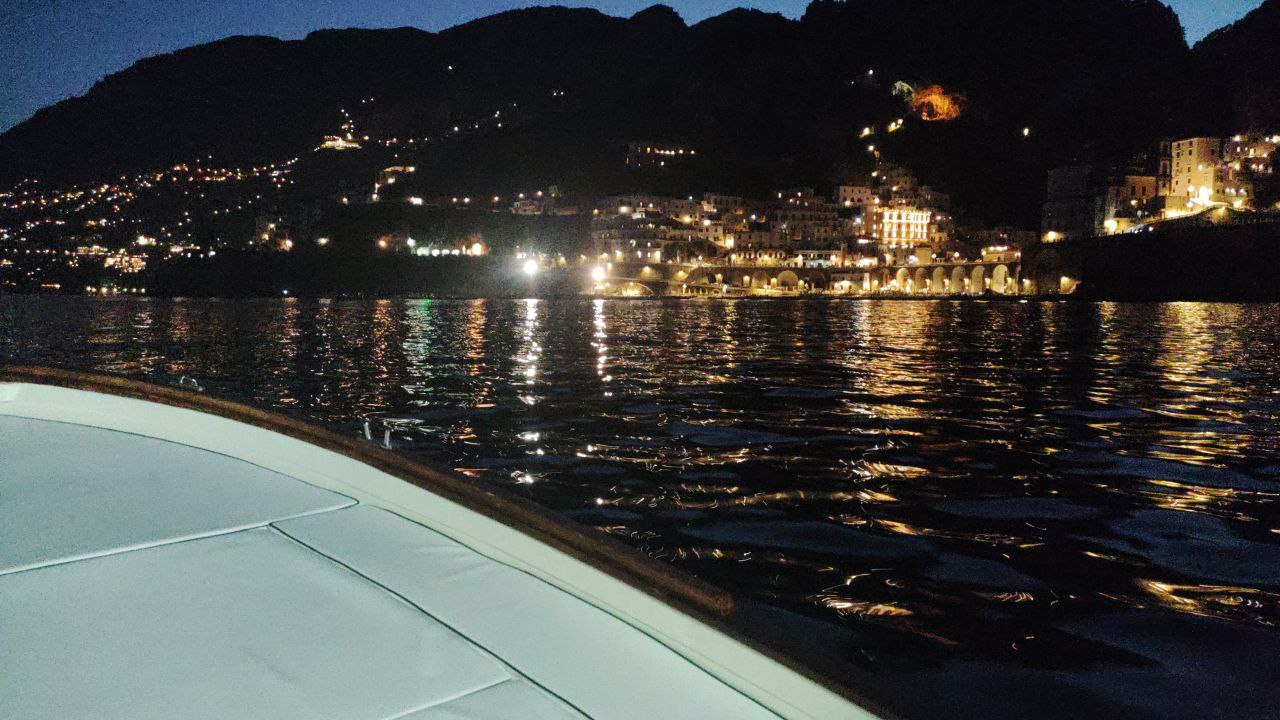 view of amalfi in the night from the boat 