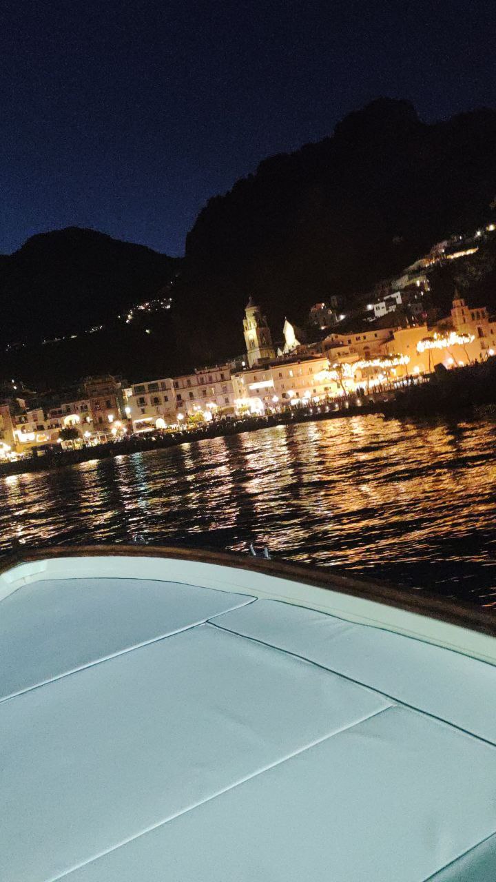 view of amalfi in the night from the boat 