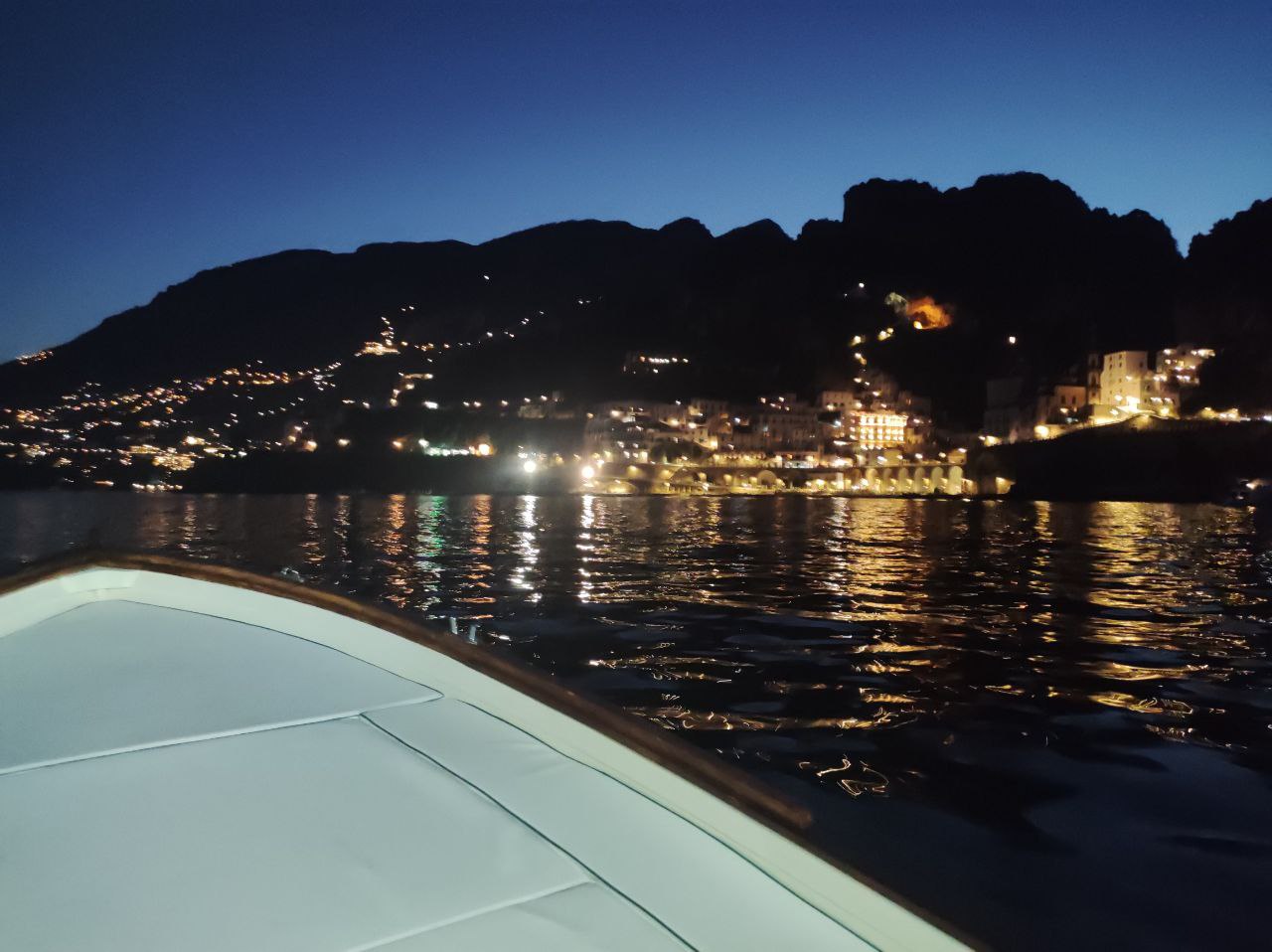 view of amalfi in the night from the boat 